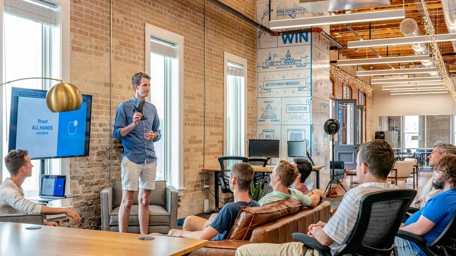 Team gathered in a loft space watching a presentation